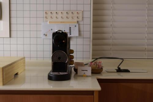 a black hair dryer sitting on top of a counter at windmill house in Daegu