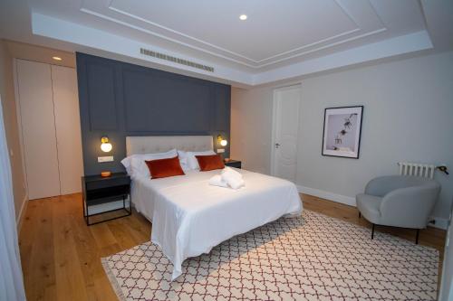 a bedroom with a large white bed and a chair at For You Rentals Lujoso y elegante ap. en Centro Madrid ALC35 in Madrid