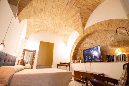 a bedroom with a bed and a tv in a room at La Rua in Ascoli Piceno
