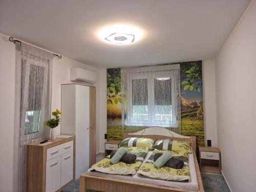 1 dormitorio con 1 cama con una pintura en la pared en Happy House Vendégház, en Bogács