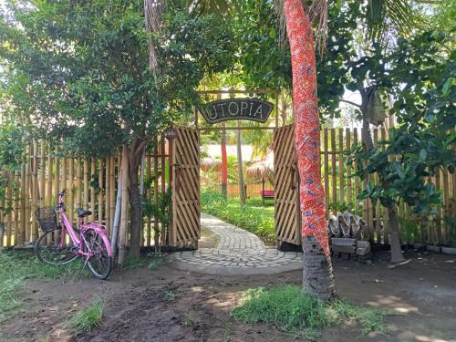 a pink bike parked next to a fence with a sign at UTOPIA in Gili Air