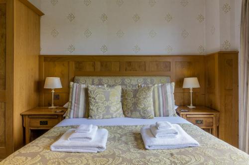 a bedroom with a bed with towels on it at Yewfield Vegetarian Guest house in Ambleside