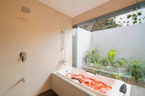 a bathroom with a sink and a large window at SaffronStays Sanvina Farm, Karjat in Karjat