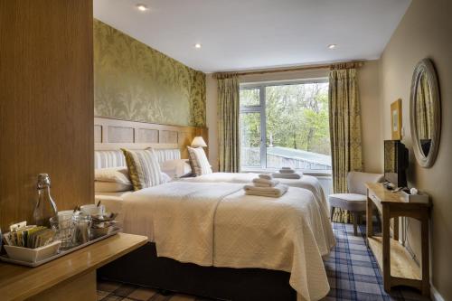 a hotel room with a bed and a window at Yewfield Vegetarian Guest house in Ambleside