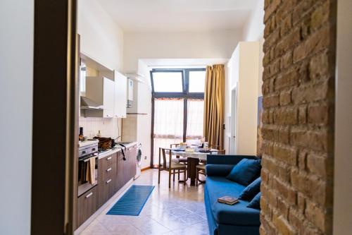 a kitchen and living room with a blue couch at La Rua in Ascoli Piceno