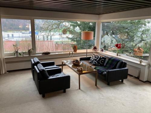 un soggiorno con 2 divani, un tavolo e finestre di Privates Zimmer & Bad in Aalen/Unterkochen a Unterkochen