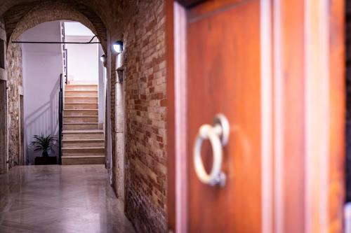 an open door with a brick wall and stairs at La Rua in Ascoli Piceno