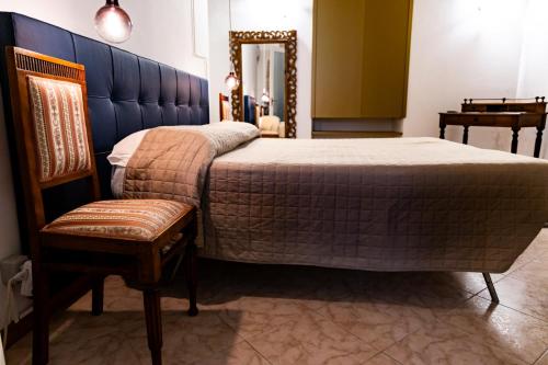 a bedroom with a bed and a chair and a mirror at La Rua in Ascoli Piceno
