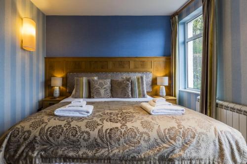 a bedroom with a large bed with two towels on it at Yewfield Vegetarian Guest house in Ambleside