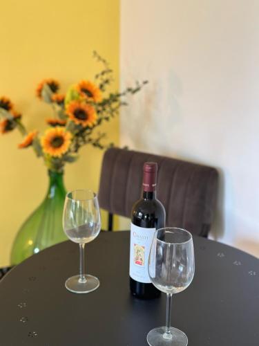 Casa Rilore في Ostra Vetere: زجاجة من النبيذ وكأسين من النبيذ على الطاولة