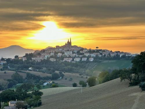 a town on top of a hill at sunset at Casa Rilore in Ostra Vetere