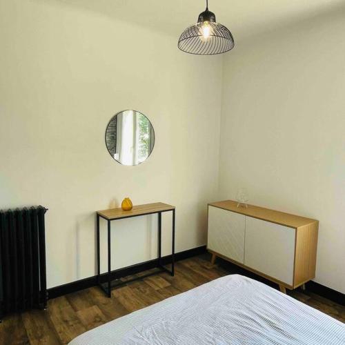 une chambre avec un lit et un miroir au mur dans l'établissement Charmant T2 tout équipé face à la gare, à Lorient