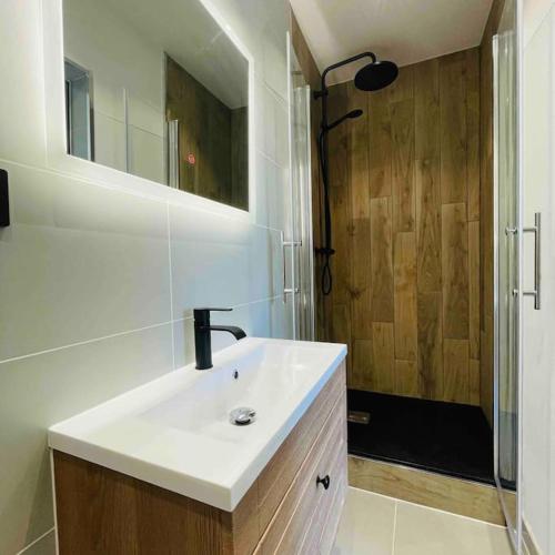 une salle de bain blanche avec un lavabo et une douche dans l'établissement Charmant T2 tout équipé face à la gare, à Lorient