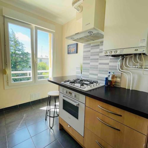 une cuisine avec une cuisinière et un comptoir dans l'établissement Charmant T2 tout équipé face à la gare, à Lorient