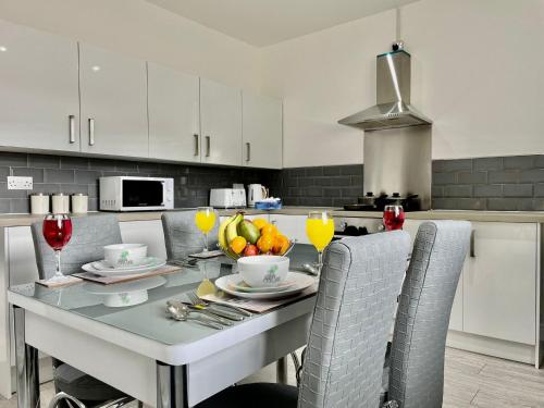 a kitchen with a table with a bowl of fruit on it at Cheerful 3-bedroom Near Bikepark Wales Merthyr Tydfil Town Centre in Merthyr Tydfil
