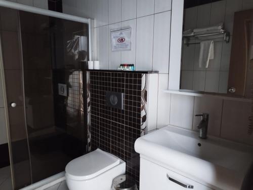 uma casa de banho com um WC, um lavatório e um chuveiro em LÜKS HOTEL em Mersin