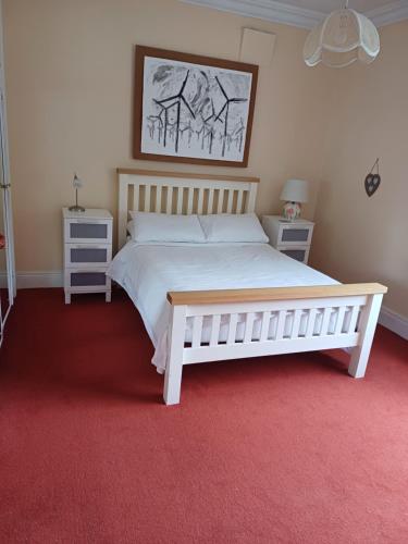 a bedroom with a white bed and two night stands at Lara, Maynooth W23P9H6 in Maynooth