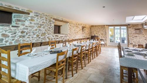 La Ferme des 3 Suissesses في Saint-Paul: غرفة طعام مع طاولة وكراسي طويلة