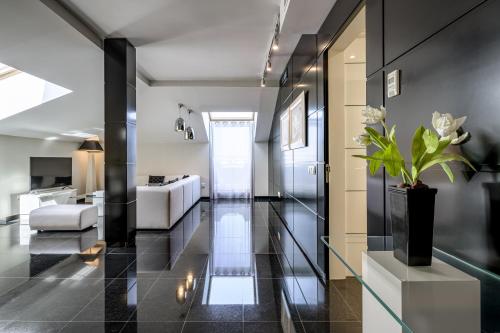 a hallway with black tile flooring and a living room at Hotel Nelva in Murcia