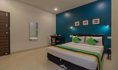 a bedroom with a large bed with a blue wall at Treebo Tulip Comfort in Pune
