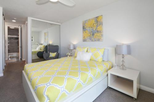 1 dormitorio con 1 cama grande y edredón amarillo y blanco en D206 Seaside Serenity, en Oceanside