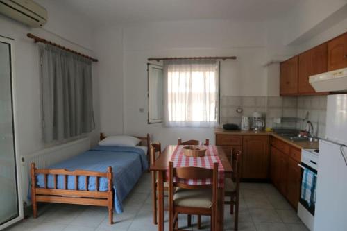 a bedroom with a bed and a table and a kitchen at Yiampanaki in Vasiliki
