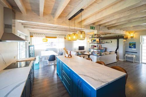 a large kitchen with blue cabinets and a living room at Las Cerezas Gozón By Silastur in Luanco