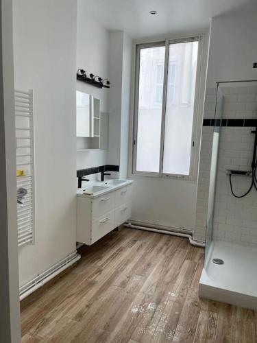 une salle de bain blanche avec un lavabo et une douche dans l'établissement Noailles experience - Centre Marseille /Vieux-Port, à Marseille
