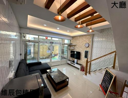 uma sala de estar com um sofá e uma televisão em 維辰包棟民宿Wei Chen Resort B&B em Xiaoliuqiu