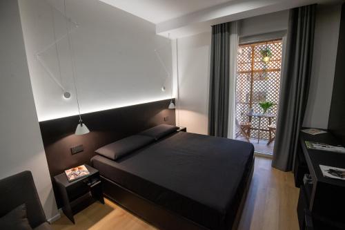 - une chambre avec un lit noir et une fenêtre dans l'établissement Contemporaneamente 147 - Modern & Comfort Rooms, à Bari