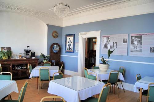 a dining room with blue walls and tables and chairs at The Lawrence of Arabia Hotel in Weymouth