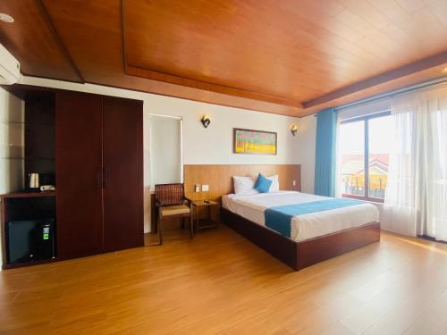 a bedroom with a bed and a large window at SenDa Villa & Apartment Hoi An in Hoi An