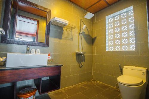 a bathroom with a sink and a toilet and a window at SenDa Villa & Apartment Hoi An in Hoi An