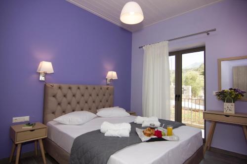 1 dormitorio con 2 camas, paredes de color púrpura y ventana en angelastudios-stoupa, en Stoupa