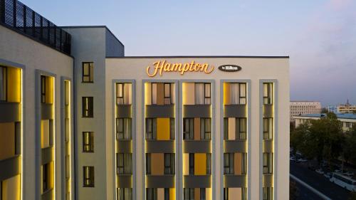 a hotel building with a sign on top of it at Hampton By Hilton Tashkent in Tashkent