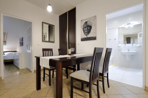 a dining room with a table and chairs and a bathroom at Dworek Różany Hotel & Restauracja in Namysłów