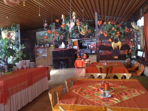 a dining room with two tables with orange tablecloths at Ferienwohnung - Apartement - Hotel Klippitz Nordost in Reichenfels
