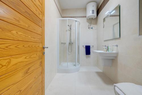 a bathroom with a shower and a toilet and a sink at Seafront Apartment Sliema in Sliema
