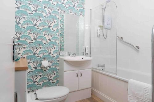 a bathroom with a toilet and a sink and a shower at Room 2, Hotel style twin bedroom in Marazion in Marazion