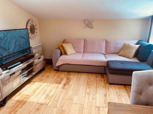 ein Wohnzimmer mit einem Sofa und einem Flachbild-TV in der Unterkunft Ático a 8 minutos de Toledo y 15 del Puy Du Fou in Bargas