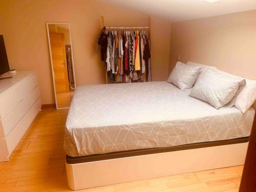 ein Schlafzimmer mit einem Bett und einem Schrank in der Unterkunft Ático a 8 minutos de Toledo y 15 del Puy Du Fou in Bargas