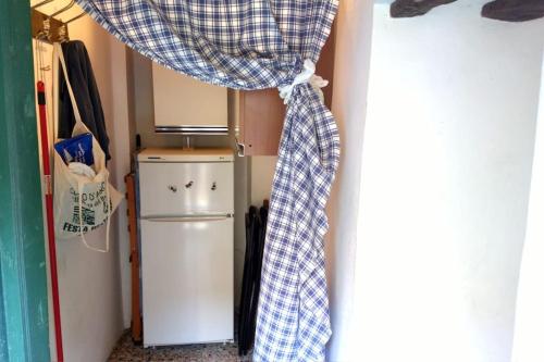 um quarto com um frigorífico e uma cortina ao lado de um frigorífico em Un tuffo vintage tra mare_monti em Pianavia