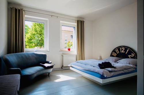 a bedroom with a bed and a chair and a window at Landhaus Oderbruch in Bad Freienwalde