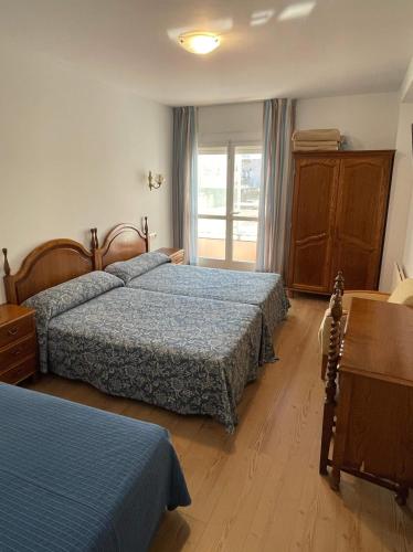 a hotel room with two beds and a window at Hotel Amandi in O Grove