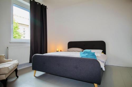 a bed sitting in a room with a window at Die Jute Stube in Bad Freienwalde