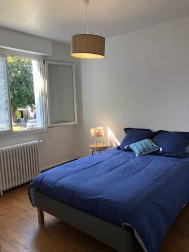 une chambre avec un lit avec des draps bleus et une fenêtre dans l'établissement Maison de vacances 10 personnes, La Tremblade, à La Tremblade