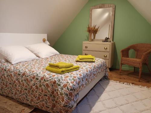 a bedroom with a bed with yellow towels on it at Ancienne maison de pêcheurs in Saint-Marcouf