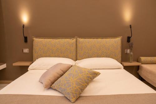 Una cama con dos almohadas encima. en BelMa' Aparthotel and Rooms en Marina di Camerota