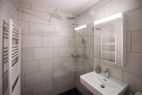 a white bathroom with a sink and a mirror at Moderne & helle Wohnung mit Netflix & Bergsicht in Wetzikon