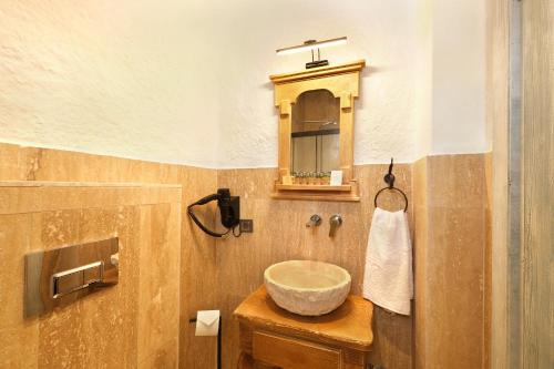 a bathroom with a bowl sink and a mirror at Armel Alaçatı in Alacati